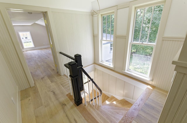 239 Ocean Point Rd, Boothbay, ME 04544 - stairway with a decorative wall, wood finished floors, plenty of natural light, vaulted ceiling, and a wainscoted wall