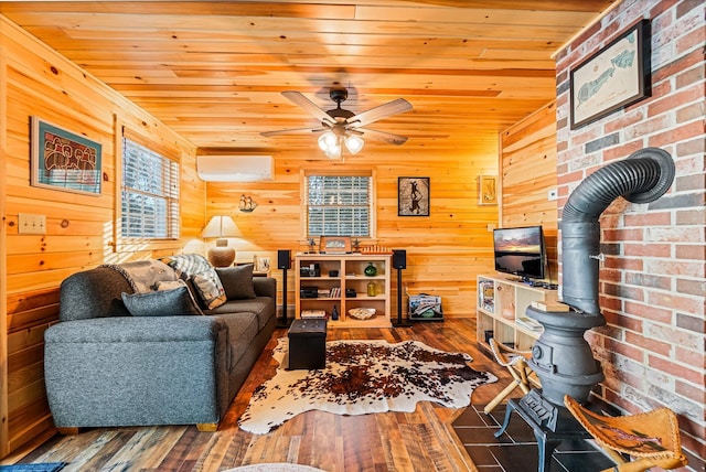 36 Worcester Way, Lincoln, ME 04457 - living area featuring a wall unit AC, wooden ceiling, ceiling fan, a wood stove, and wood finished floors