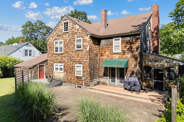 36 Woodlawn Ave, Auburn, ME 04210 - back of property featuring a chimney, a shingled roof, and a patio area