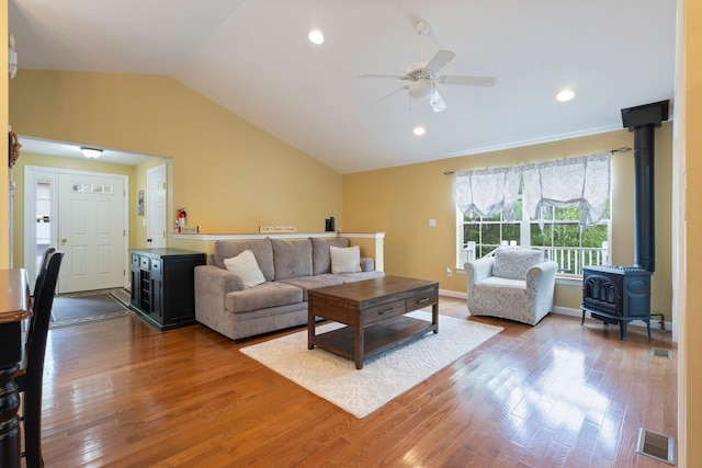 1313 Deer Run, Casco, ME 04015 - living area with vaulted ceiling, a ceiling fan, wood finished floors, a wood stove, and recessed lighting