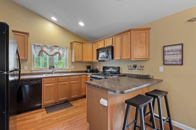 1313 Deer Run, Casco, ME 04015 - kitchen with black appliances, a peninsula, lofted ceiling, dark countertops, and light wood-style flooring