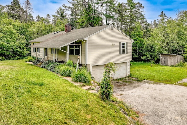 421 Cushing Rd, Cushing, ME 04563 - view of front of property with dirt driveway, a chimney, a front lawn, an attached garage, and a storage shed