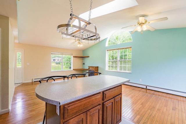 421 Cushing Rd, Cushing, ME 04563 - kitchen with ceiling fan, light wood-type flooring, vaulted ceiling, brown cabinetry, and plenty of natural light