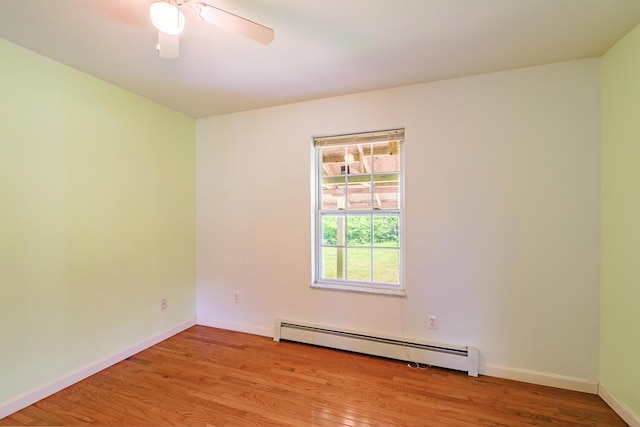 421 Cushing Rd, Cushing, ME 04563 - spare room featuring a baseboard heating unit, wood finished floors, and a ceiling fan