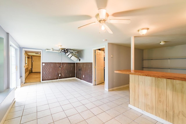 421 Cushing Rd, Cushing, ME 04563 - unfurnished living room with a bar, a ceiling fan, and light tile patterned floors