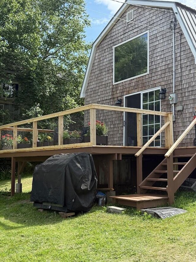 631 US Rt 1, Robbinston, ME 04671 - back of house with a gambrel roof, a wooden deck, stairway, and a yard