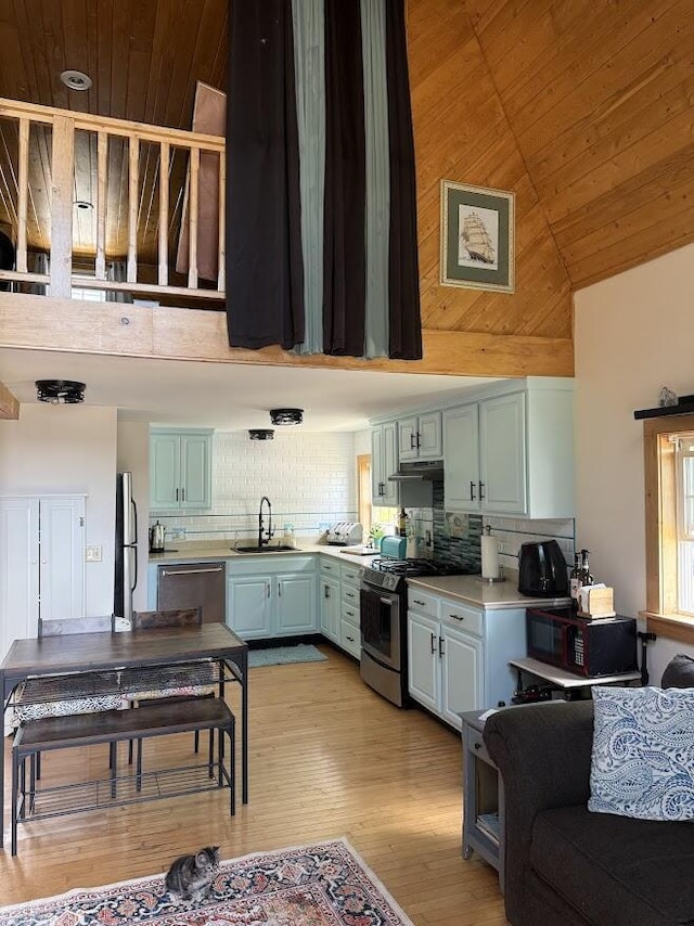631 US Rt 1, Robbinston, ME 04671 - kitchen featuring stainless steel appliances, wood ceiling, high vaulted ceiling, decorative backsplash, and light wood-style flooring
