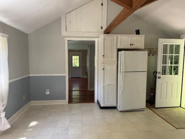 27 Dodge Rd, Edgecomb, ME 04556 - kitchen with freestanding refrigerator, lofted ceiling, and white cabinetry