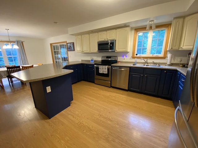 48 Stoney Ridge Rd, Eddington, ME 04428 - kitchen featuring appliances with stainless steel finishes, a peninsula, light wood-style flooring, white cabinets, and hanging light fixtures