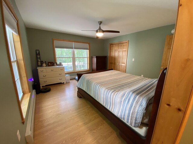 48 Stoney Ridge Rd, Eddington, ME 04428 - bedroom featuring light wood finished floors, a baseboard radiator, a closet, and a ceiling fan
