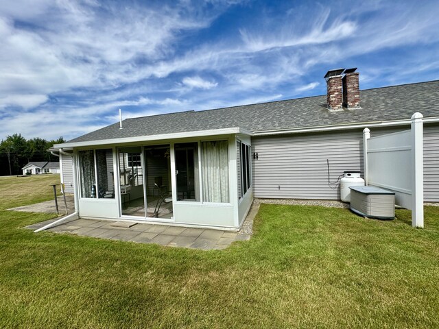 35A Birchbrook Ln Unit 35A, Levant, ME 04456 - back of house with a sunroom, a chimney, a shingled roof, and a yard