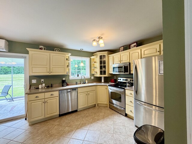 35A Birchbrook Ln Unit 35A, Levant, ME 04456 - kitchen with stainless steel appliances, light tile patterned flooring, glass insert cabinets, hanging light fixtures, and open shelves
