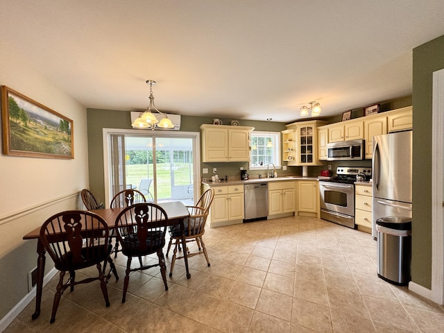 35A Birchbrook Ln Unit 35A, Levant, ME 04456 - kitchen featuring appliances with stainless steel finishes, light countertops, hanging light fixtures, glass insert cabinets, and light tile patterned flooring
