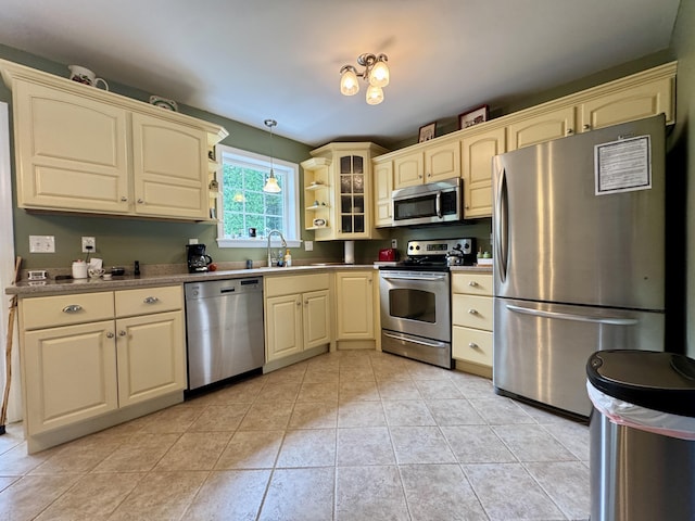 35A Birchbrook Ln Unit 35A, Levant, ME 04456 - kitchen with appliances with stainless steel finishes, cream cabinets, pendant lighting, glass insert cabinets, and light tile patterned flooring