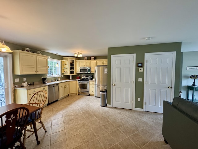 35A Birchbrook Ln Unit 35A, Levant, ME 04456 - kitchen with appliances with stainless steel finishes, glass insert cabinets, cream cabinetry, and light countertops