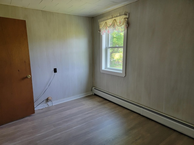 183 Folsom Pond Rd, Lincoln, ME 04457 - unfurnished room with a baseboard heating unit and wood finished floors