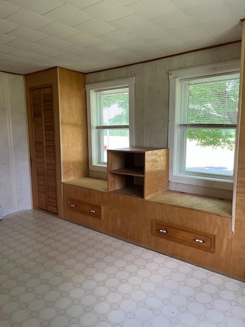 183 Folsom Pond Rd, Lincoln, ME 04457 - interior space with plenty of natural light, tile patterned floors, and wood walls