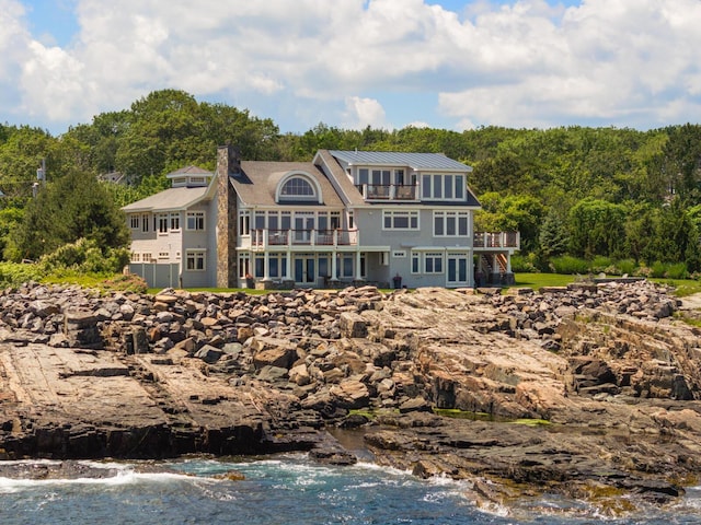 121 Bald Head Cliff Rd, York, ME 03902 - rear view of house with a balcony, a wooded view, a metal roof, and a chimney