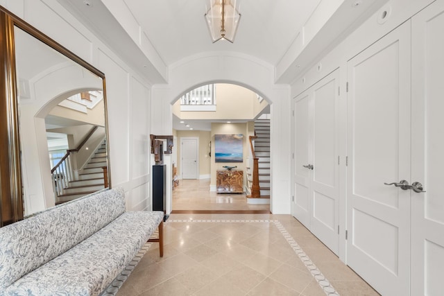 121 Bald Head Cliff Rd, York, ME 03902 - hallway with arched walkways, stairway, inlaid floor details, light tile patterned floors, and high vaulted ceiling