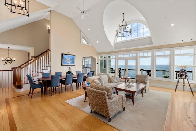 121 Bald Head Cliff Rd, York, ME 03902 - living room featuring a chandelier, arched walkways, high vaulted ceiling, light wood-style floors, and stairway