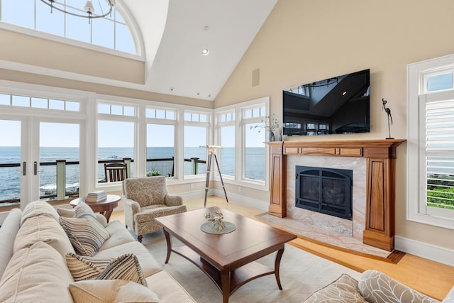 121 Bald Head Cliff Rd, York, ME 03902 - living area featuring high vaulted ceiling, a high end fireplace, a water view, light wood-style floors, and recessed lighting