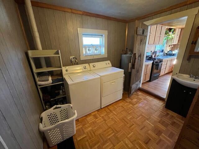 6 Chicken St, Starks, ME 04911 - laundry area with wood walls, independent washer and dryer, water heater, and ornamental molding