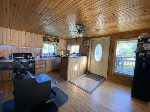 6 Chicken St, Starks, ME 04911 - kitchen featuring black appliances, wood walls, light brown cabinets, a peninsula, and wooden ceiling