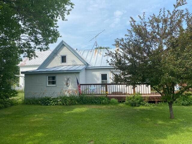 6 Chicken St, Starks, ME 04911 - back of property with a standing seam roof, a lawn, a wooden deck, and a metal roof
