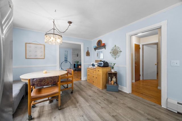 97 Forest Ave, Orono, ME 04473 - dining area with light wood-type flooring, a chandelier, baseboard heating, and ornamental molding
