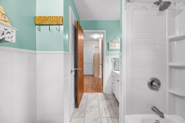 97 Forest Ave, Orono, ME 04473 - full bathroom featuring tile walls, marble look tile flooring, wainscoting, vanity, and  shower combination