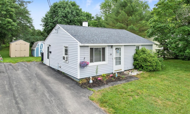 119 Falvey St, Bangor, ME 04401 - view of front of home with a storage unit, a shingled roof, a front yard, and a chimney