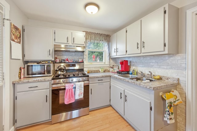 119 Falvey St, Bangor, ME 04401 - kitchen with stainless steel appliances, under cabinet range hood, light countertops, and backsplash
