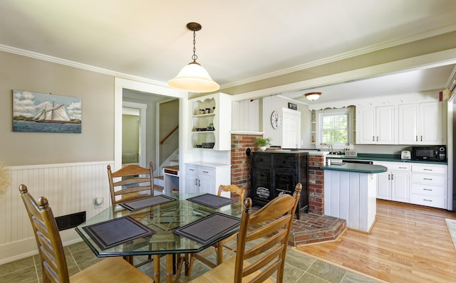 302 Townsend Ave, Boothbay Harbor, ME 04538 - dining space with stairway, crown molding, a wainscoted wall, and a brick fireplace