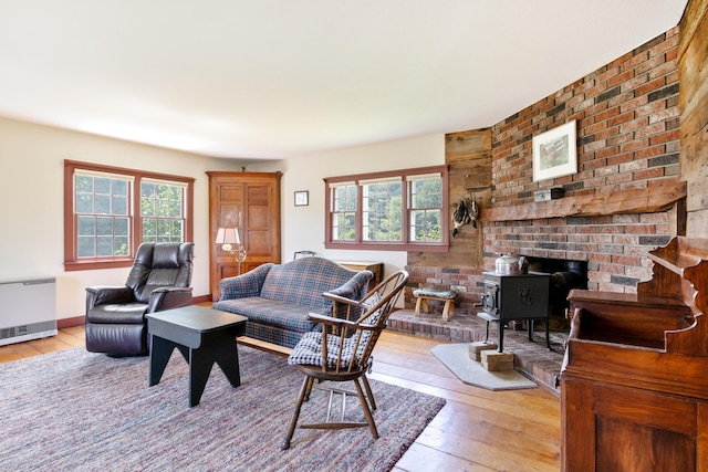 426 Meadow Rd, Topsham, ME 04086 - living area featuring a wood stove, light wood-style floors, and radiator heating unit