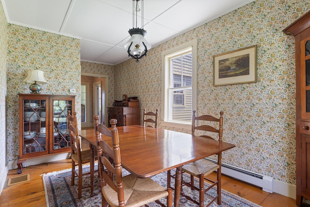 426 Meadow Rd, Topsham, ME 04086 - dining area with light wood-style flooring, ornamental molding, a baseboard radiator, and wallpapered walls