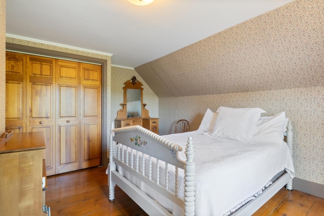426 Meadow Rd, Topsham, ME 04086 - bedroom with wallpapered walls, wood-type flooring, and lofted ceiling