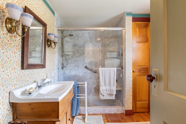 426 Meadow Rd, Topsham, ME 04086 - full bathroom with wallpapered walls, a stall shower, vanity, and wood finished floors