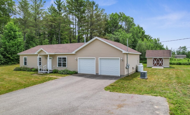 31 Silas Warren Dr, Hermon, ME 04401 - view of front facade featuring a front yard, a garage, a storage unit, and a shingled roof