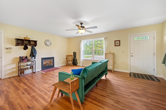 31 Silas Warren Dr, Hermon, ME 04401 - living area featuring light wood-type flooring, a ceiling fan, and a glass covered fireplace