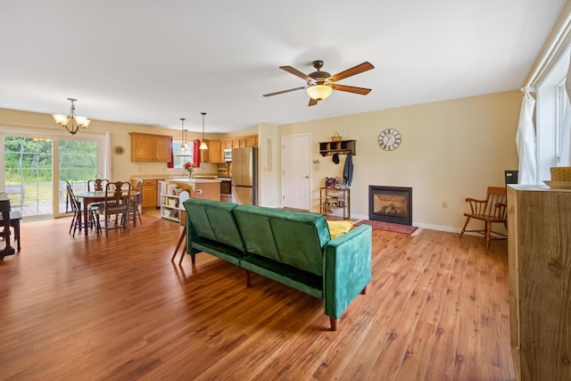 31 Silas Warren Dr, Hermon, ME 04401 - living room with light wood-style flooring, ceiling fan, a glass covered fireplace, and a chandelier