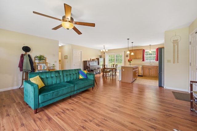 31 Silas Warren Dr, Hermon, ME 04401 - living area featuring light wood-style floors, a ceiling fan, and a chandelier