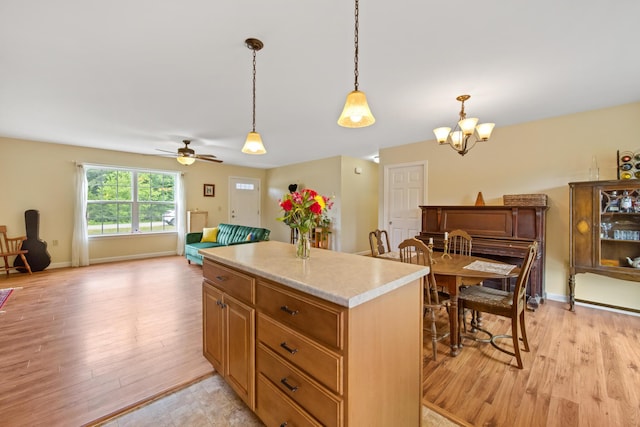 31 Silas Warren Dr, Hermon, ME 04401 - kitchen featuring light wood-style flooring, light countertops, a kitchen island, and pendant lighting