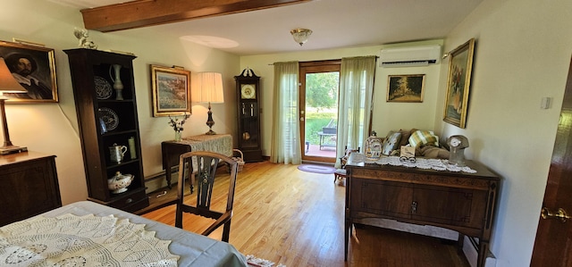 987 Clinton Ave, Winslow, ME 04901 - bedroom featuring an AC wall unit, access to exterior, wood finished floors, a baseboard heating unit, and beam ceiling