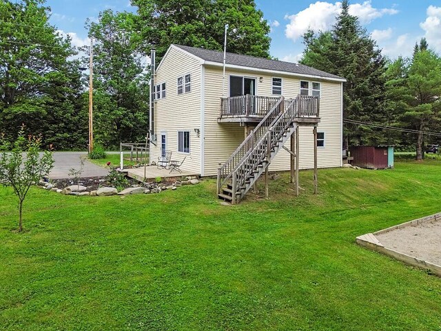 71 Morgan Rd, Burnham, ME 04922 - back of property with a wooden deck, stairway, a patio area, and a lawn
