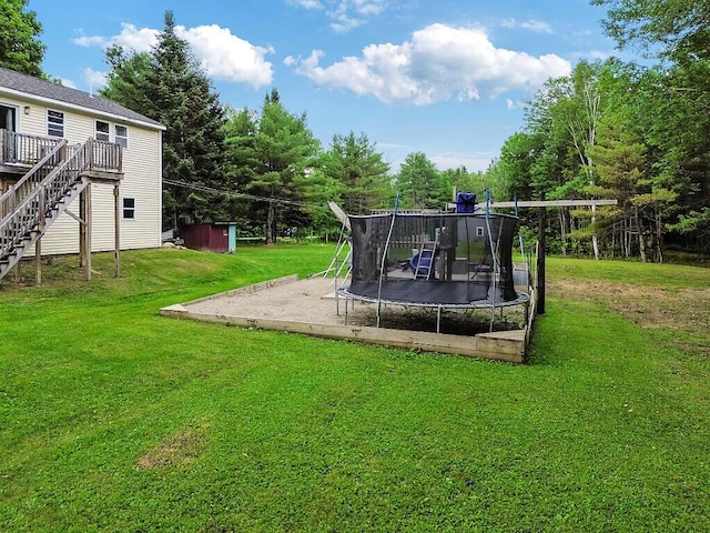 71 Morgan Rd, Burnham, ME 04922 - view of green lawn with a trampoline, a deck, and stairs