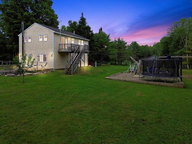 71 Morgan Rd, Burnham, ME 04922 - view of grassy yard featuring a trampoline, stairs, and a deck