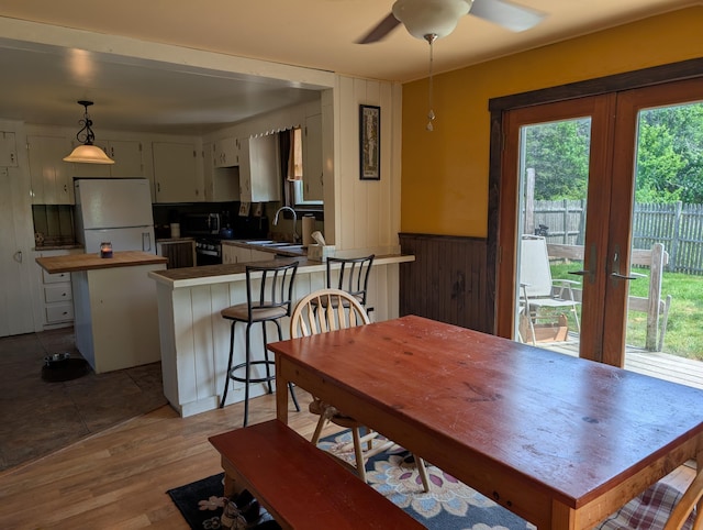 419 Common Rd, Union, ME 04862 - dining area featuring a ceiling fan, wainscoting, light wood-style flooring, and wood walls