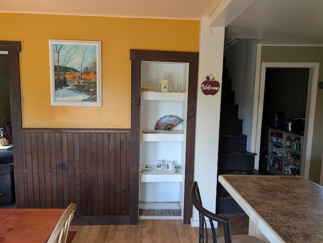 419 Common Rd, Union, ME 04862 - dining area featuring wood finished floors, built in shelves, a wainscoted wall, stairway, and wood walls