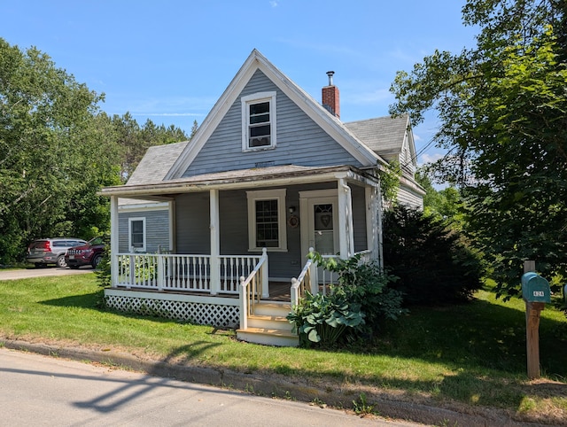 419 Common Rd, Union, ME 04862 - view of front of home with covered porch, a chimney, roof with shingles, and a front yard