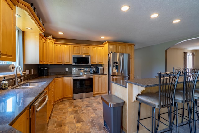 78 Lakeview Rd, Glenburn, ME 04401 - kitchen with stainless steel appliances, a breakfast bar, arched walkways, recessed lighting, and stone finish flooring